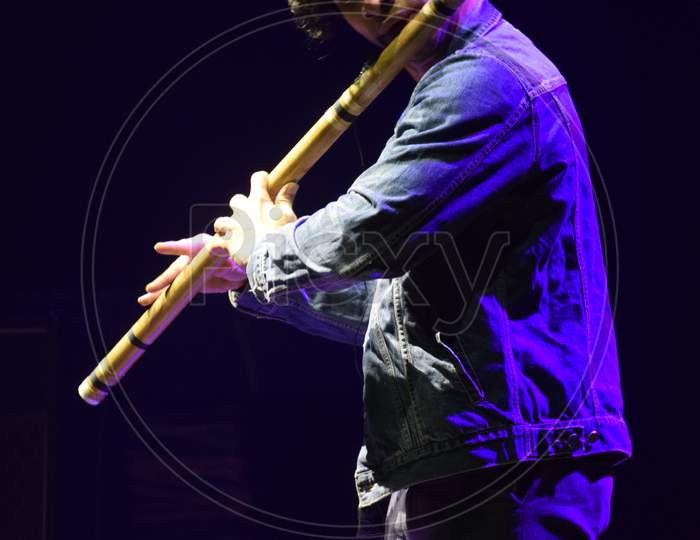 A Flutist Performing on Stage At an Live Concert Or College Event