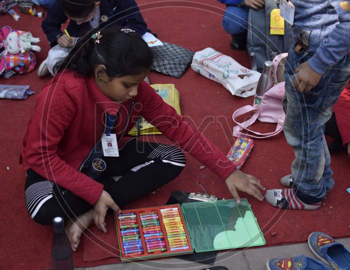 Indian school girl with box full of crayons