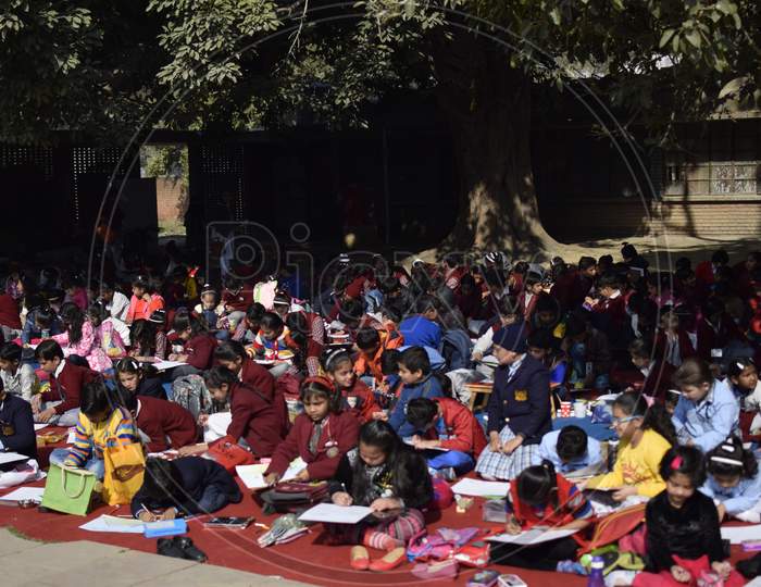 Students with drawing charts sitting on the ground of  Shantiniketan World School, Delhi