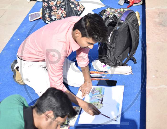 Indian boy using a paint brush during art class