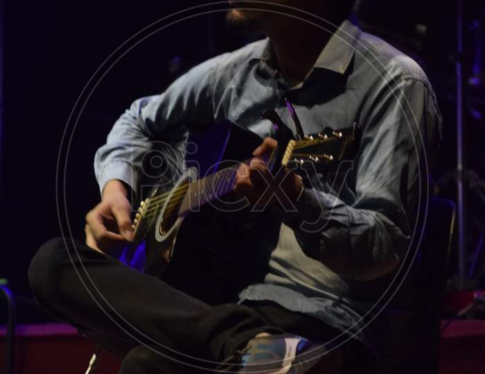 A Guitarist Performing on Stage At an Live Concert Or College Event