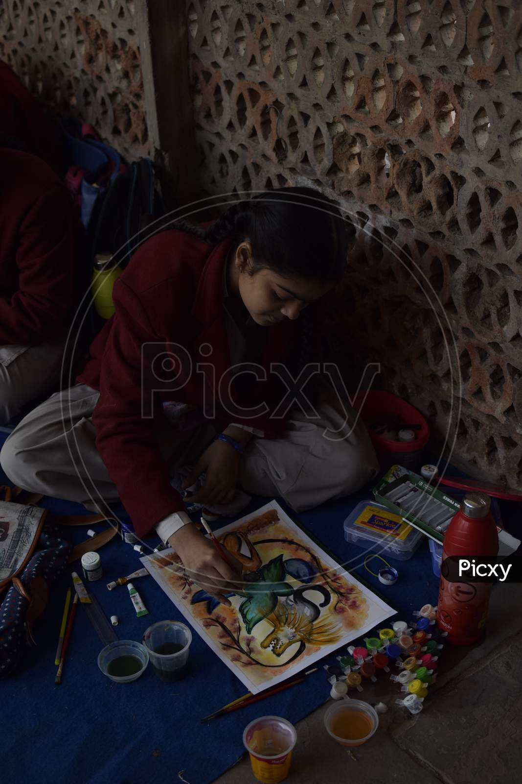 Indian school girl painting during a competition