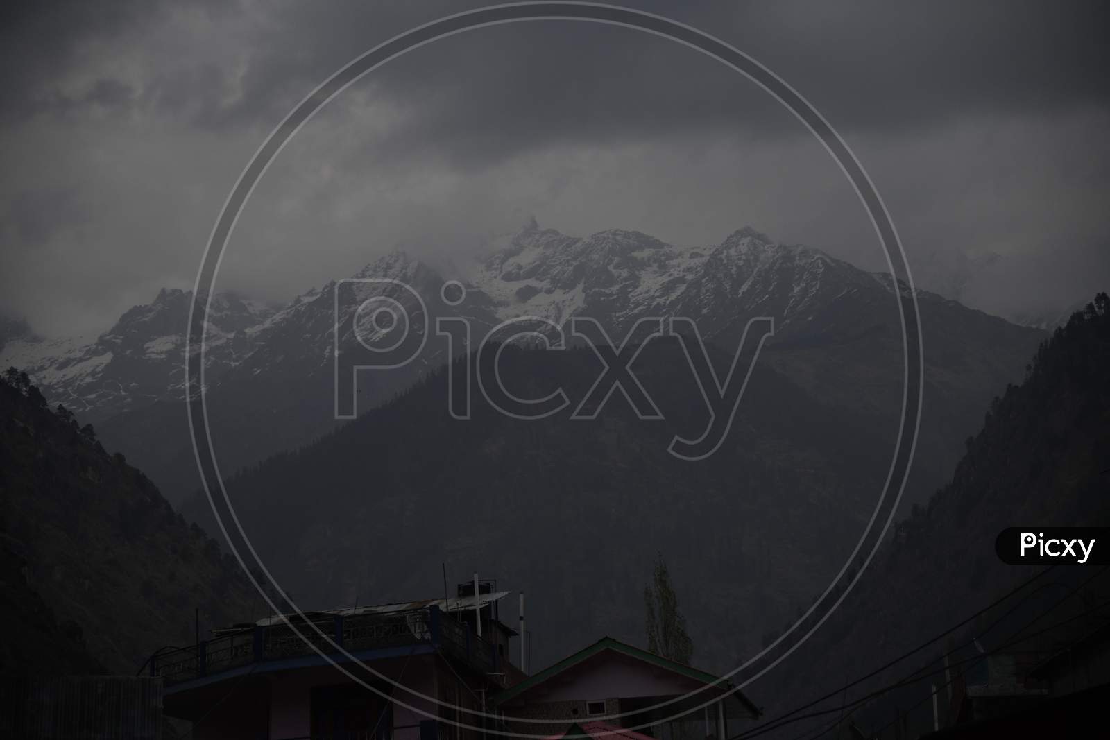 Landscape of snowy mountains with dark clouds