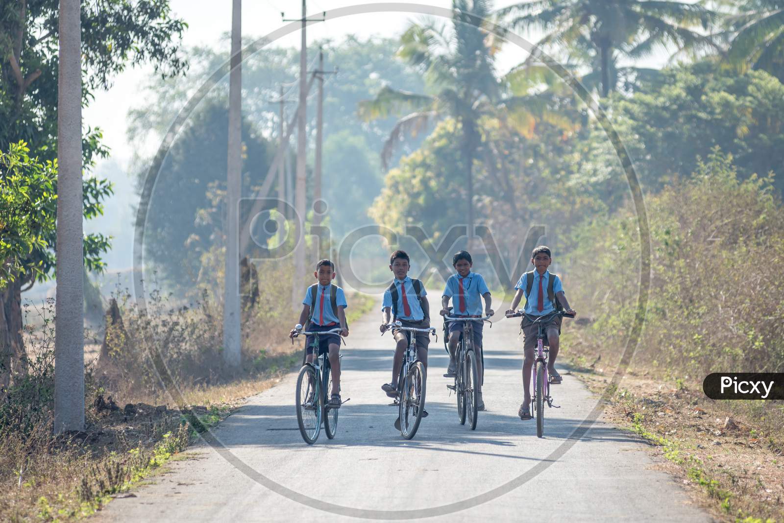 School Students Riding Cycles on Rural Village Roads