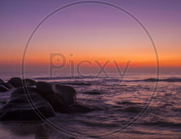 Sunset Over a Beach  with Waves And Golden Sky In Background