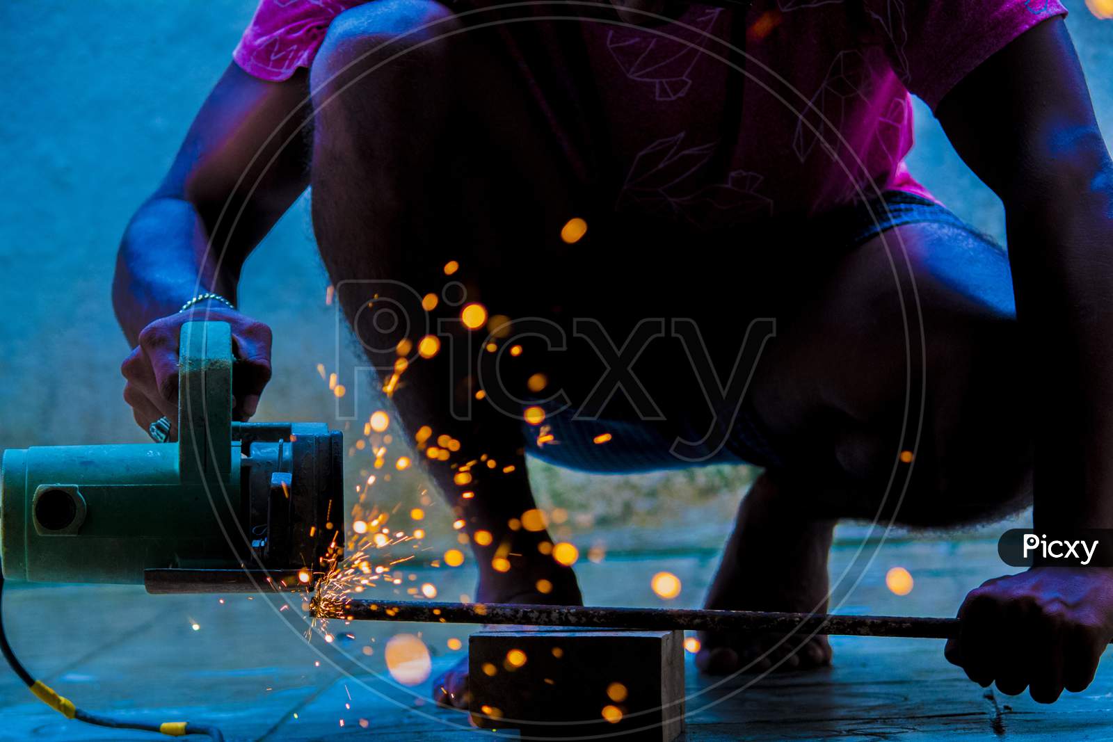 A Cutter Cutting Iron Strings With Fire Sparkles In an Workshop