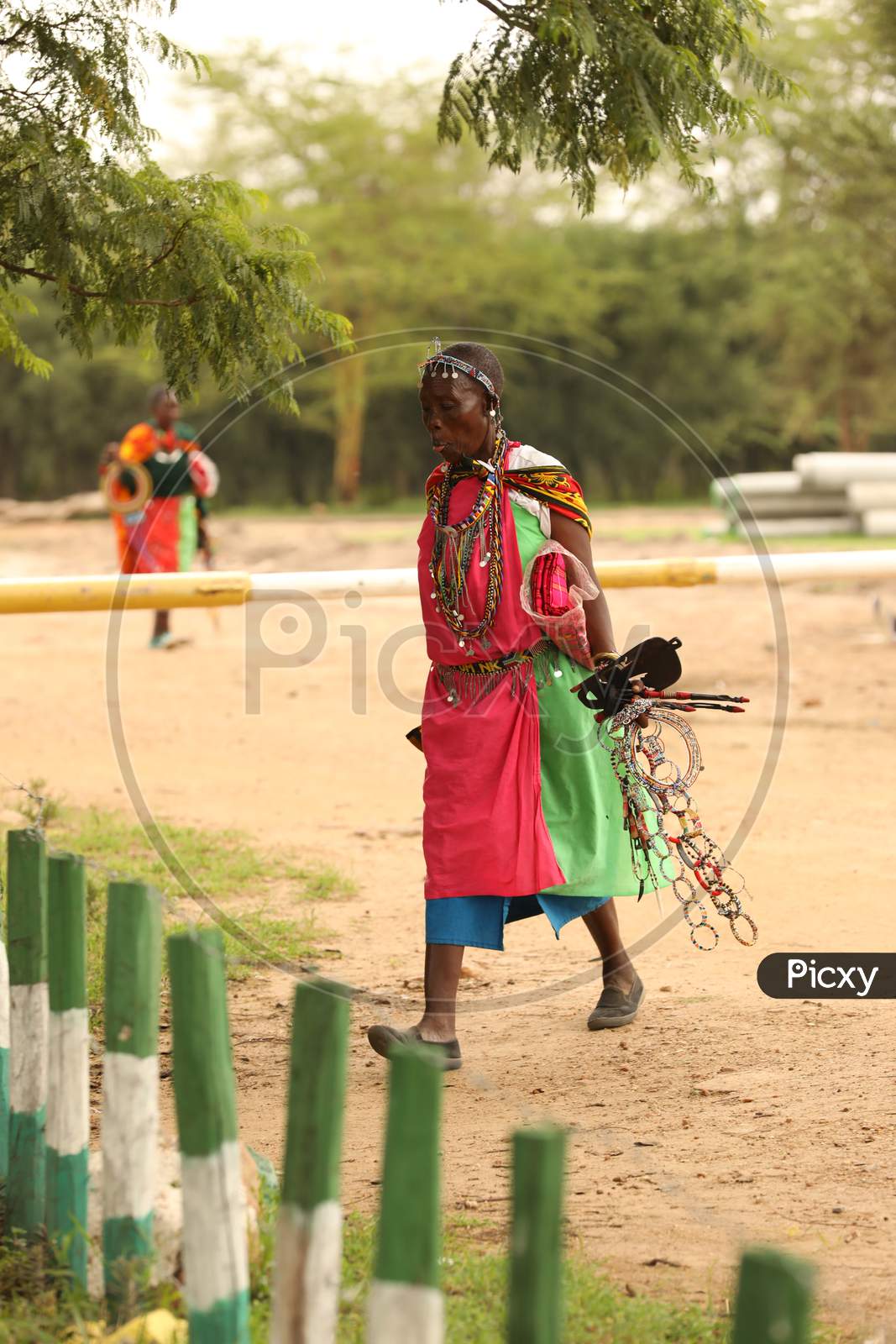 Tribal Woman walking holding accessories