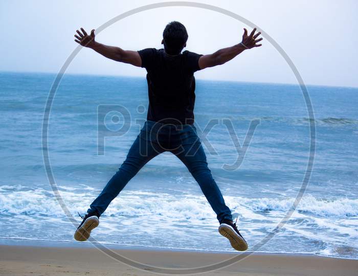 Young Man Jumping In Joy At a Beach