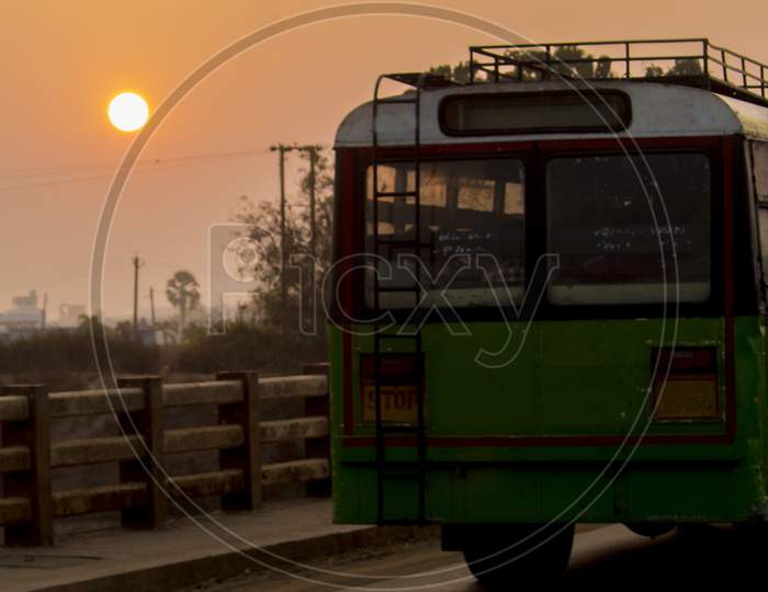 Rural Village Bus On a Bridge With Sunset Sun In Background