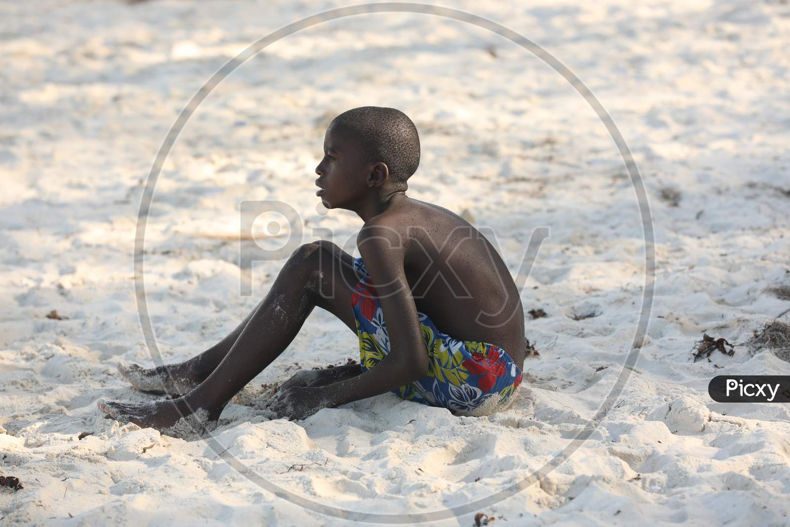 A Kenya boy sitting on the sea shore