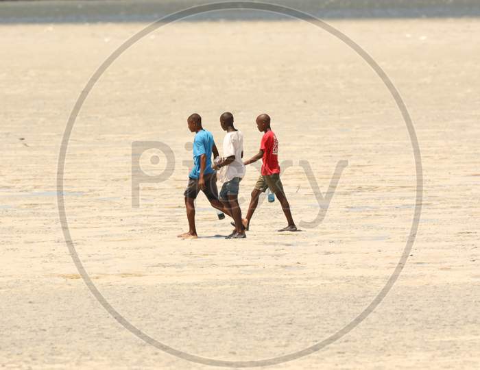 Kenya boys walking on the sand