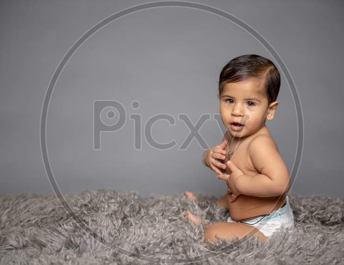 Adorable Cute Little Girl Child Playing  over a Gray Background