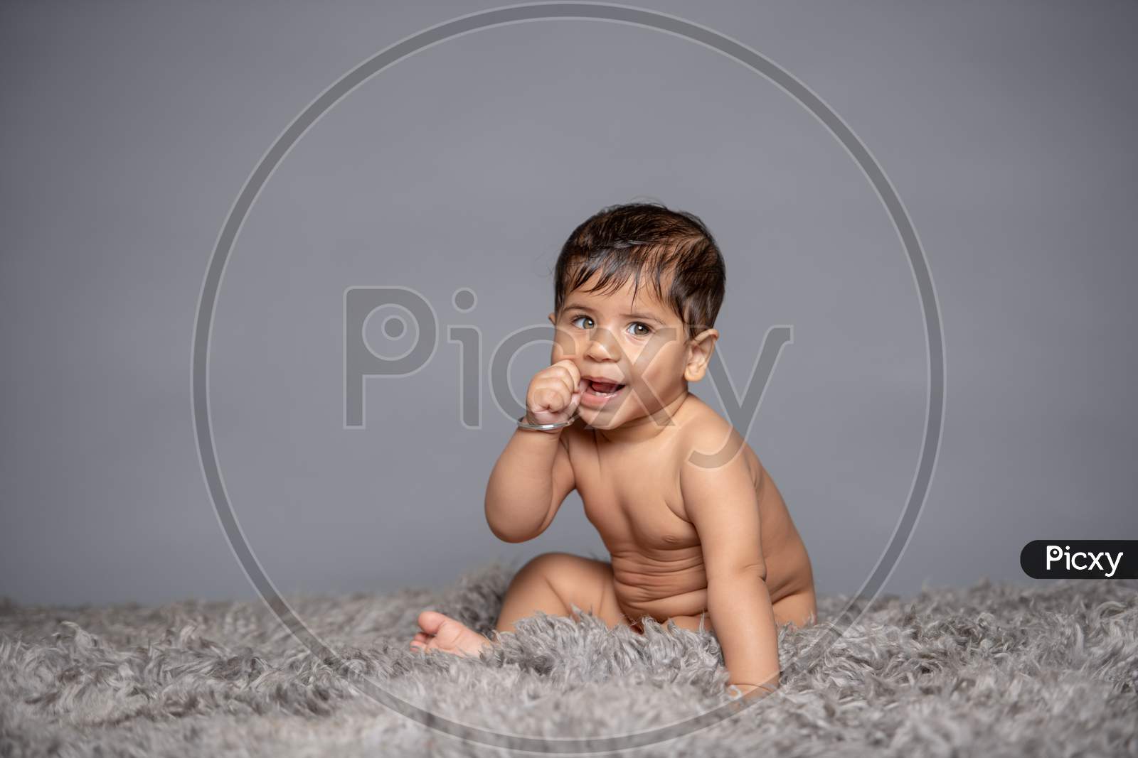 Adorable Cute Little Girl Child Playing With Toys over a Gray Background