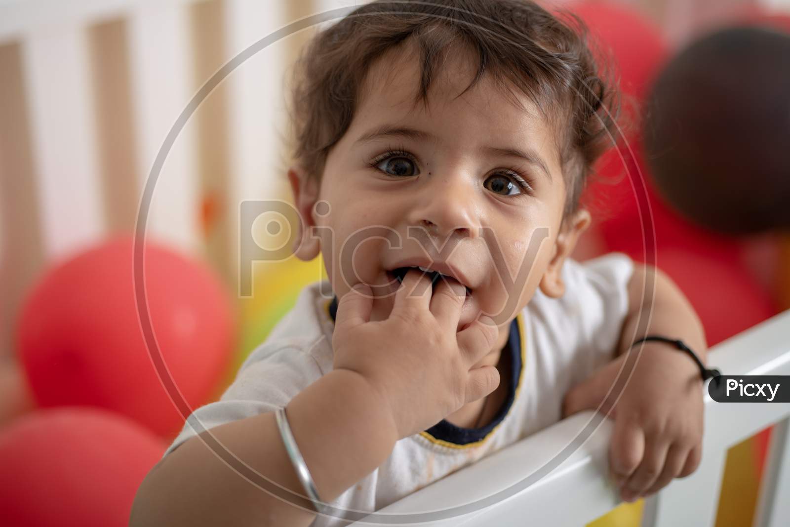 Adorable Cute Little Girl Child Playing in a Swing With Balloons And Toys In a House