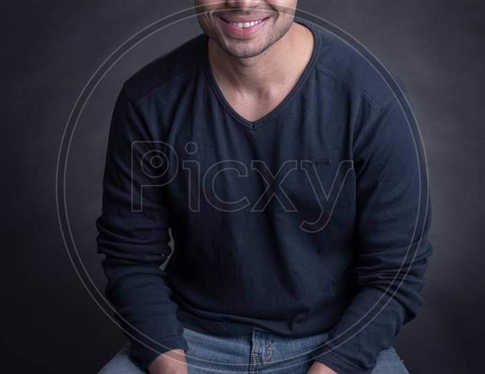 Portrait Of Young Attractive Indian Male Model Posing Over An Black Background