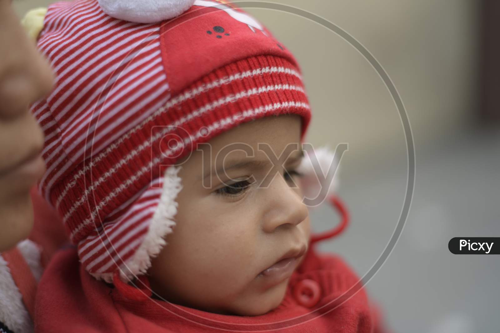 Little Girl Child Wearing a Woolen Cap and With an Expression