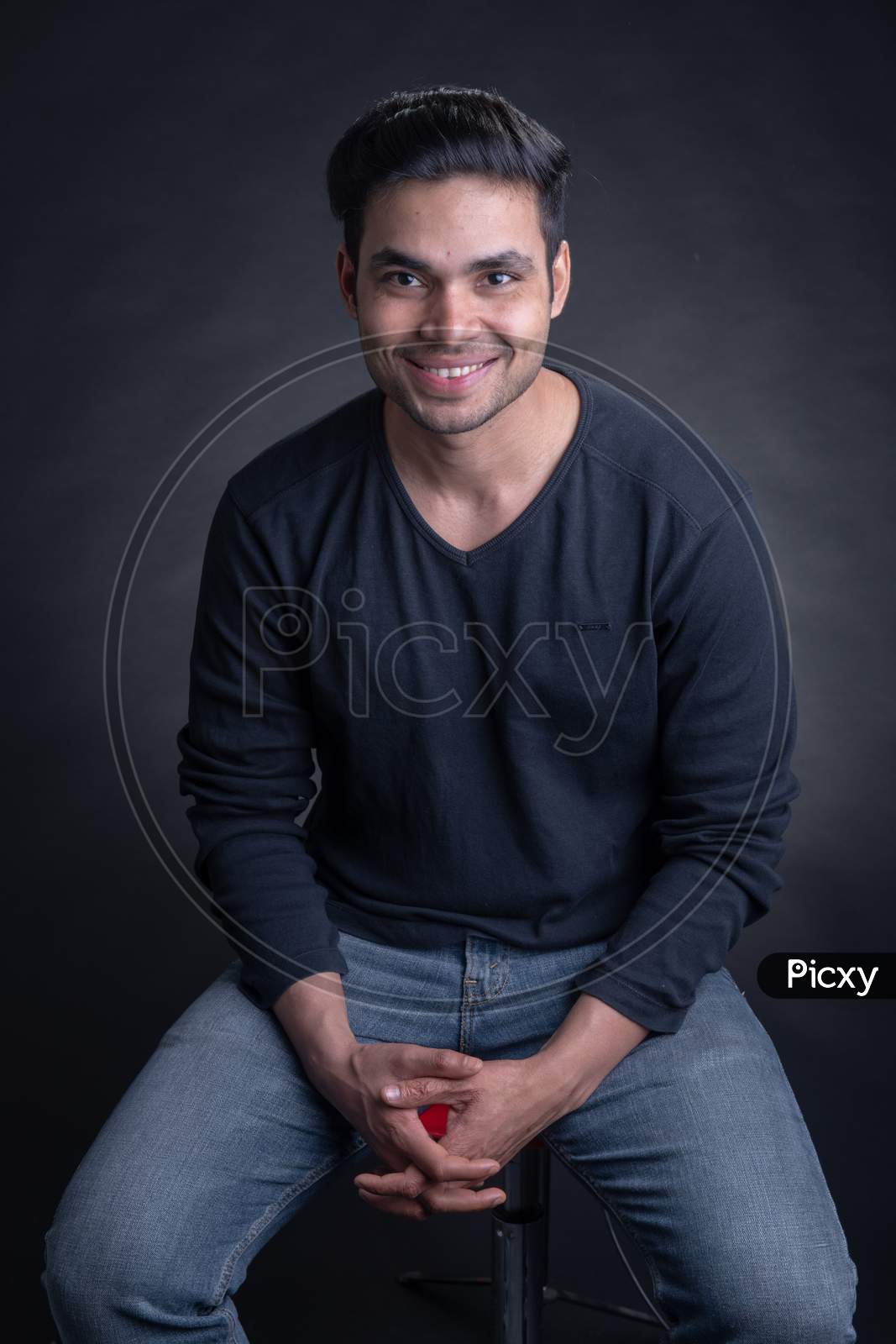 Portrait Of Young Attractive Indian Male Model Posing Over An Black Background
