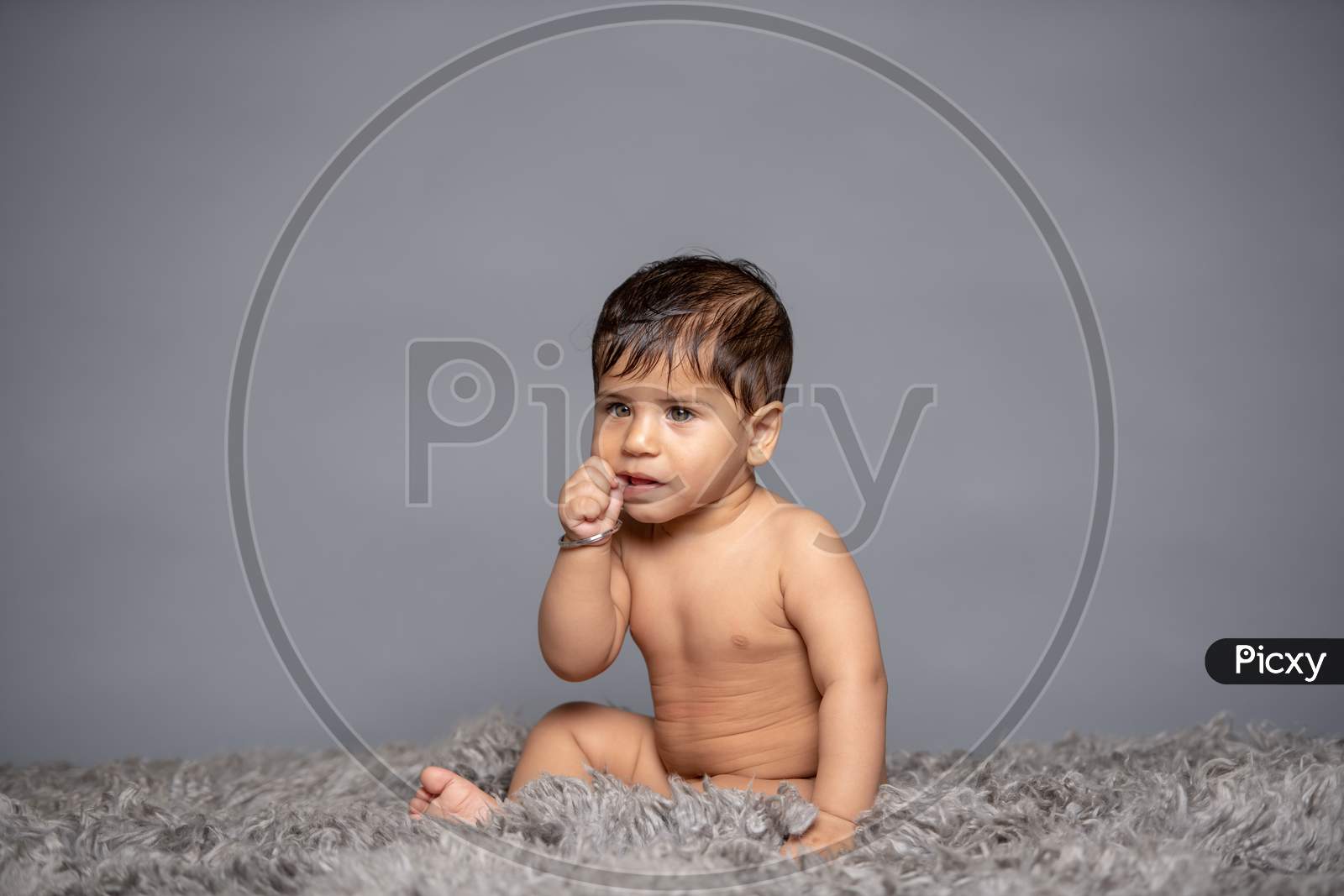 Adorable Cute Little Girl Child Playing With Toys over a Gray Background