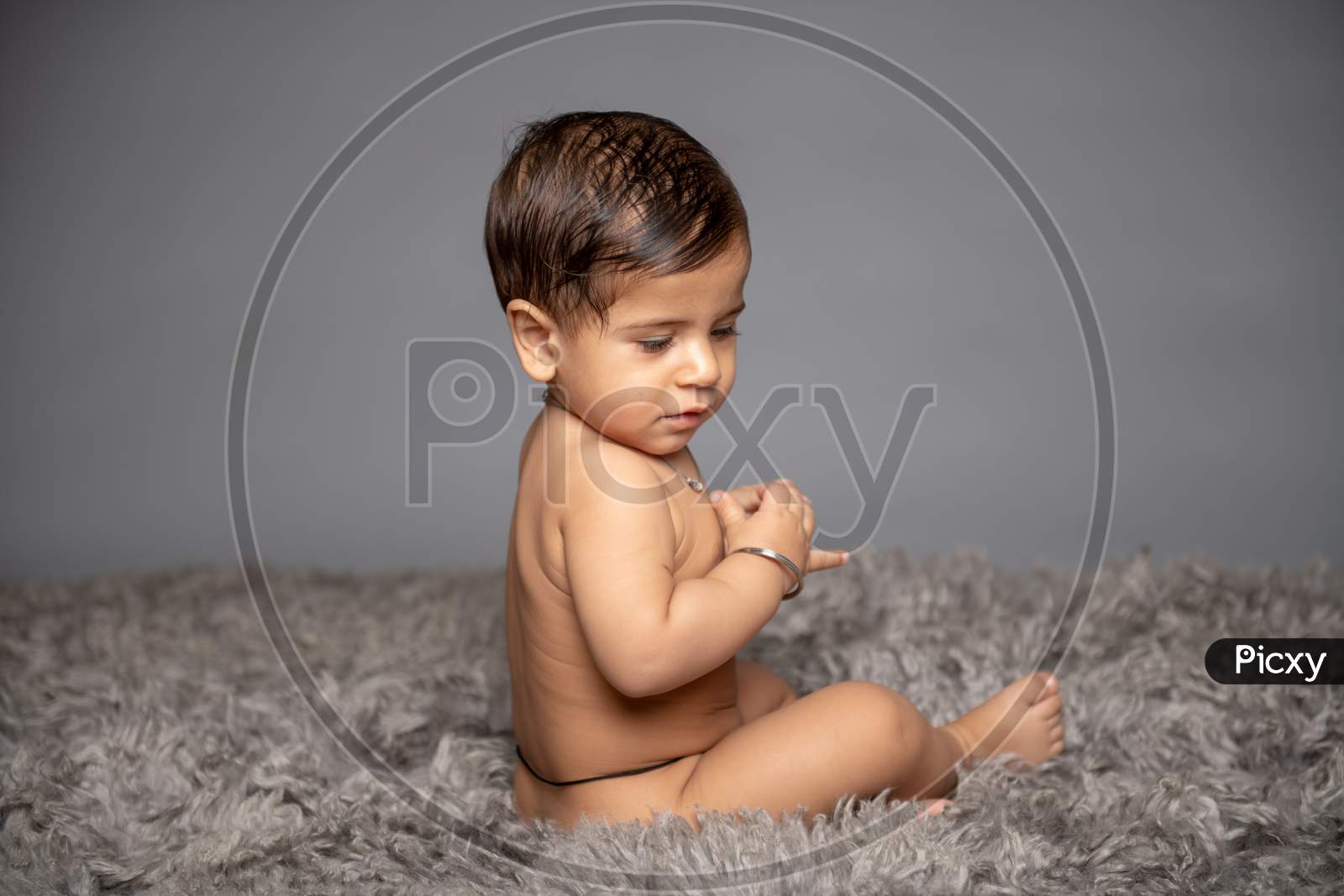 Adorable Cute Little Girl Child Playing  over a Gray Background
