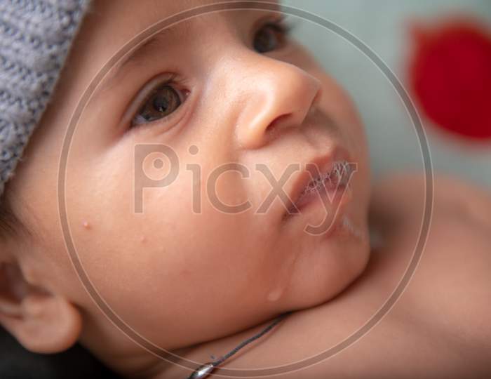 Cute Little Baby Girl Wearing Woolen Cap Face Closeup With a Smile And Innocent Expression