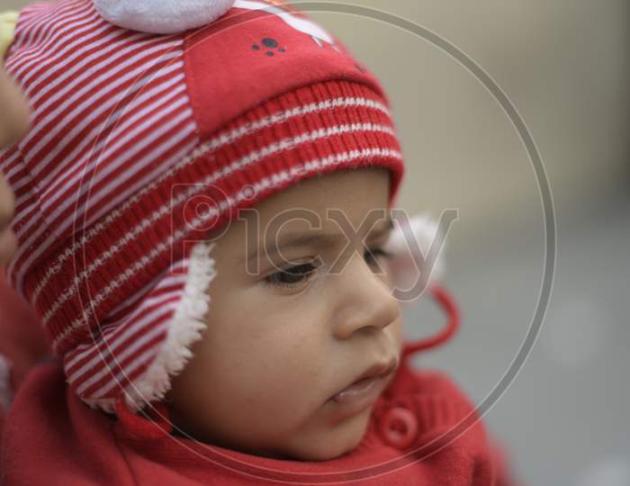 Little Girl Child Wearing a Woolen Cap and With an Expression
