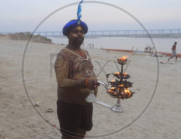 Indian Hindu Priest Performing Haarathi Or Aatrhi  To Triveni Sangam River In Prayagraj