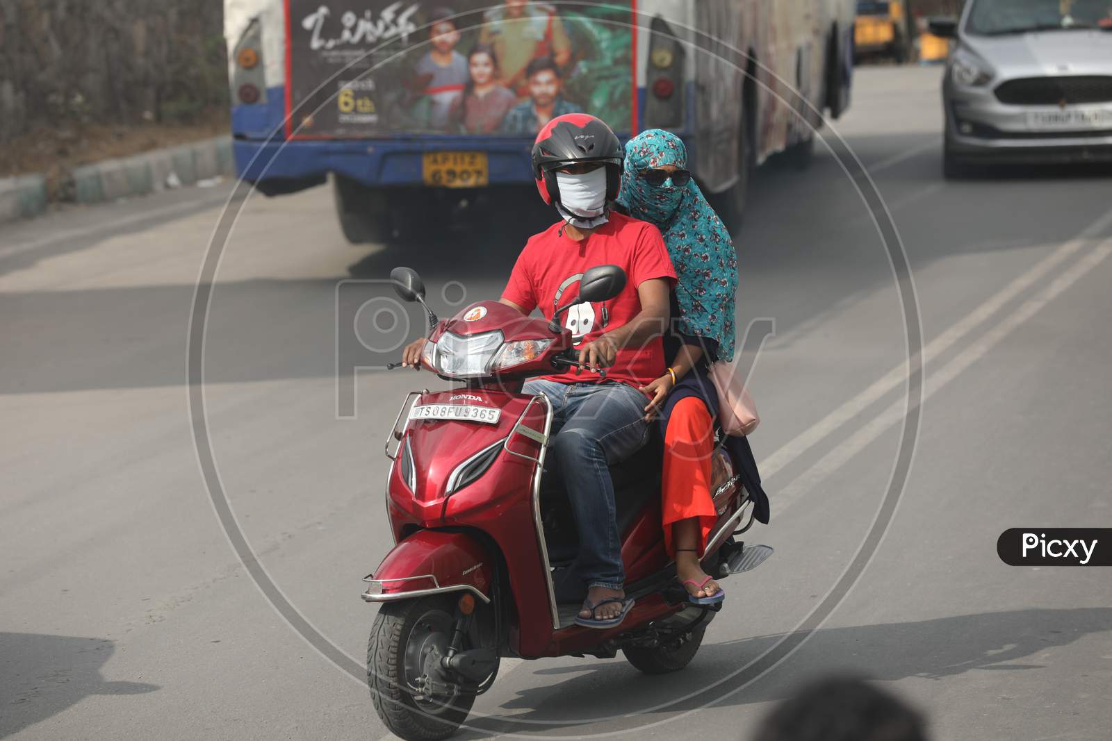 A Couple Wearing Mask While Riding On Bike