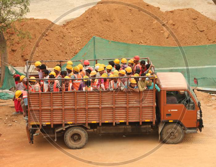 Construction Workers Getting Down From A Lorry At a Construction Site