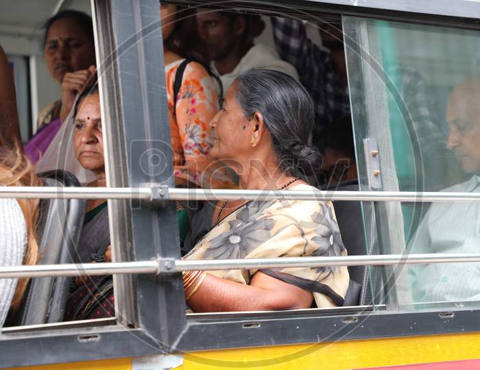 An Elderly Woman Sitting At a Window Seat In a Local Bus