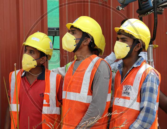 Construction Workers Wearing Safety Helmets And masks At a Construction Site