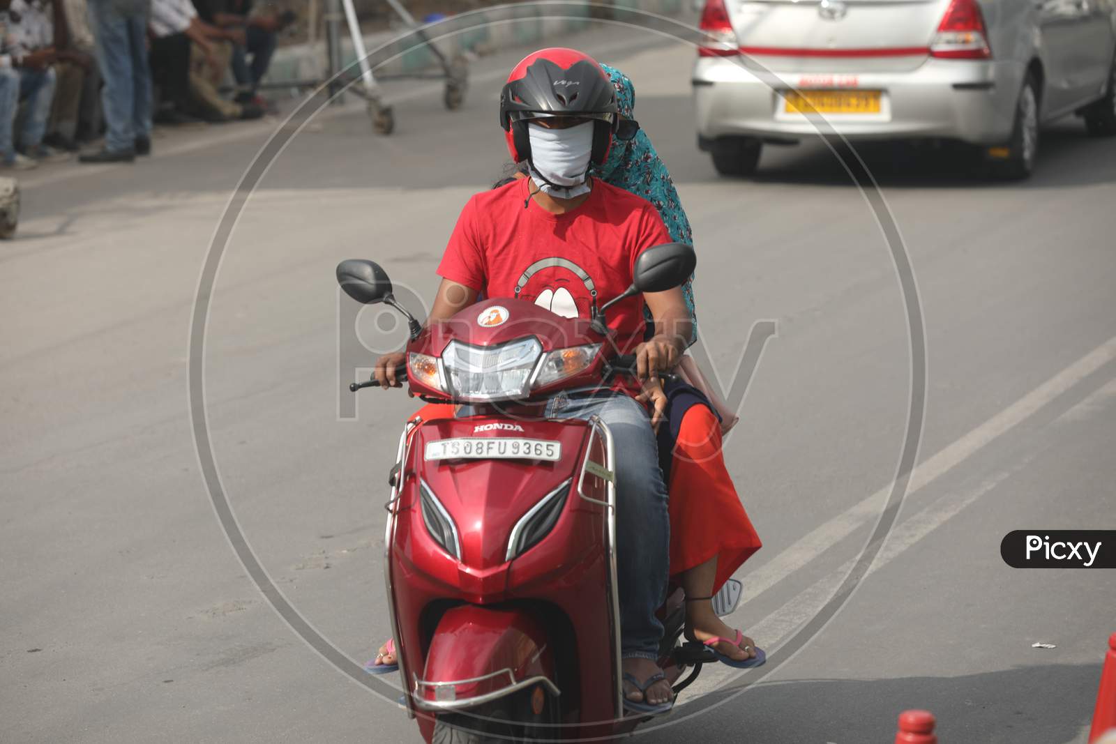 A Couple Wearing Mask While Riding On Bike