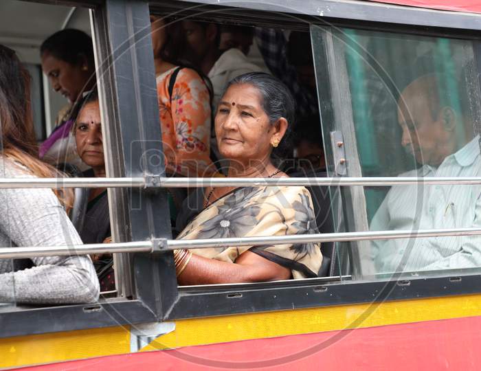 An Elderly Woman Sitting At a Window Seat In a Local Bus