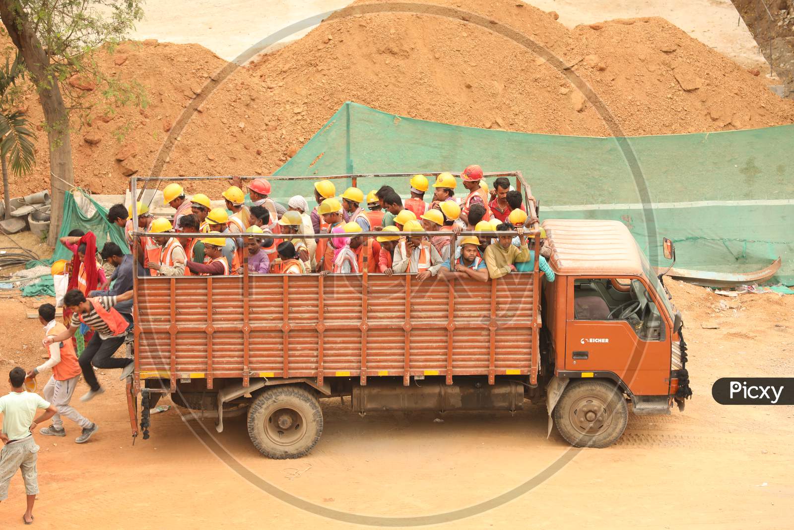 Construction Workers Getting Down From A Lorry At a Construction Site