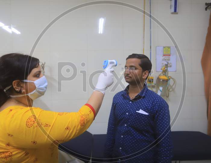 Doctor Checking A Man Wearing Mask Amidst Corona Virus Outbreak With an Thermal Senor