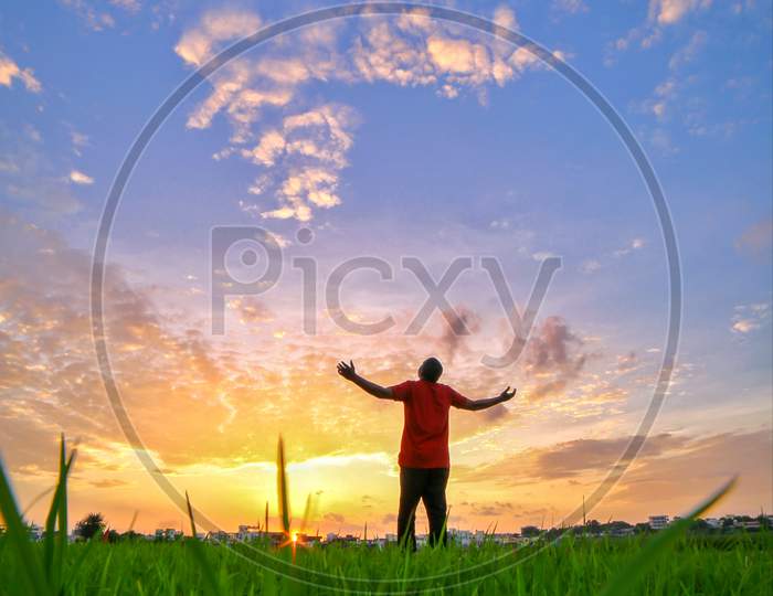 A Man Enjoying The Sunset At Paddy Fields