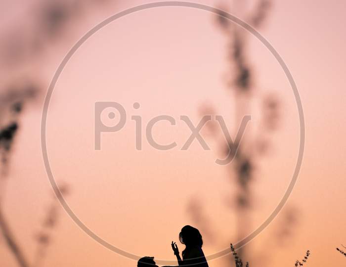 Silhouette of Couple Over Sunset Sky