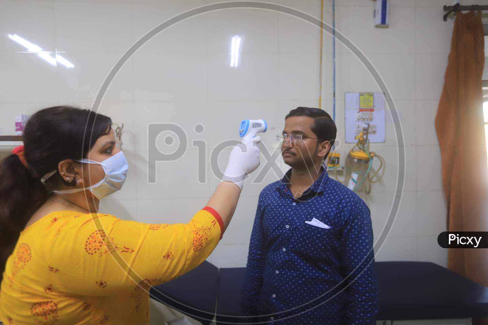 Doctor Checking A Man Wearing Mask Amidst Corona Virus Outbreak With an Thermal Senor