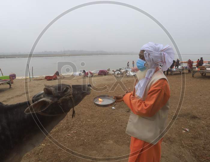 Hindu  Sadu Or baba Performing Aarthi To Holy River Triveni Sangam Wearing Surgical Mask For Safety From Corona Virus Outbreak  In India At Prayagraj