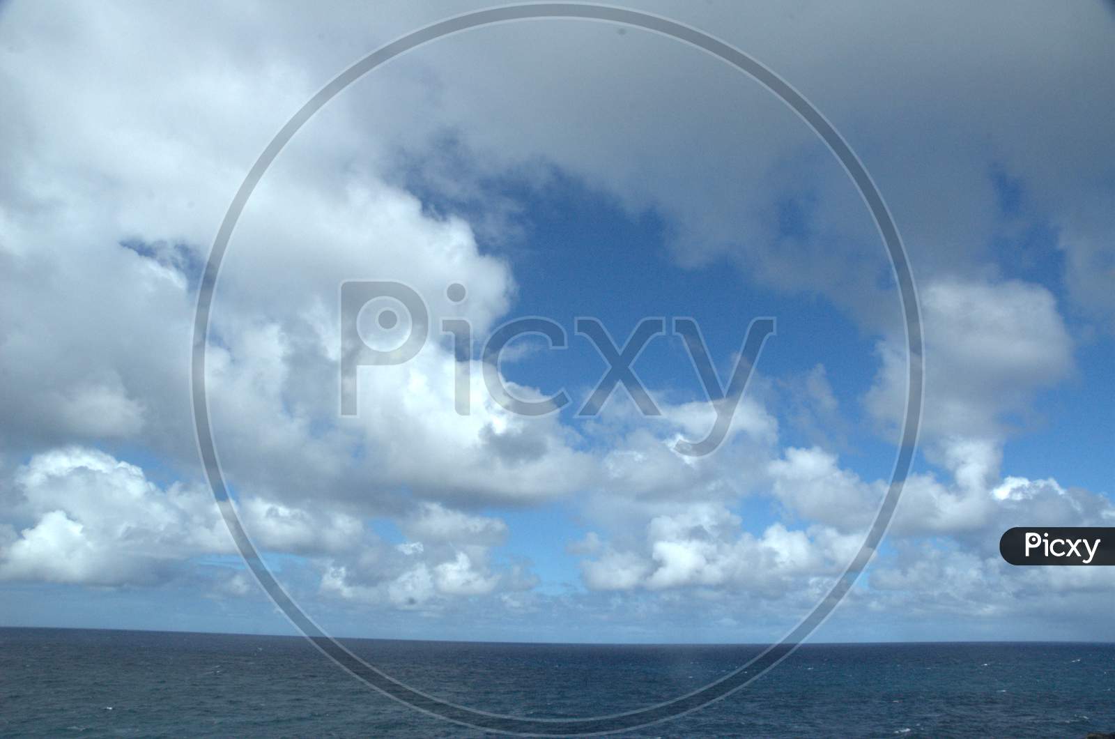 Sea And Sky With White Clouds