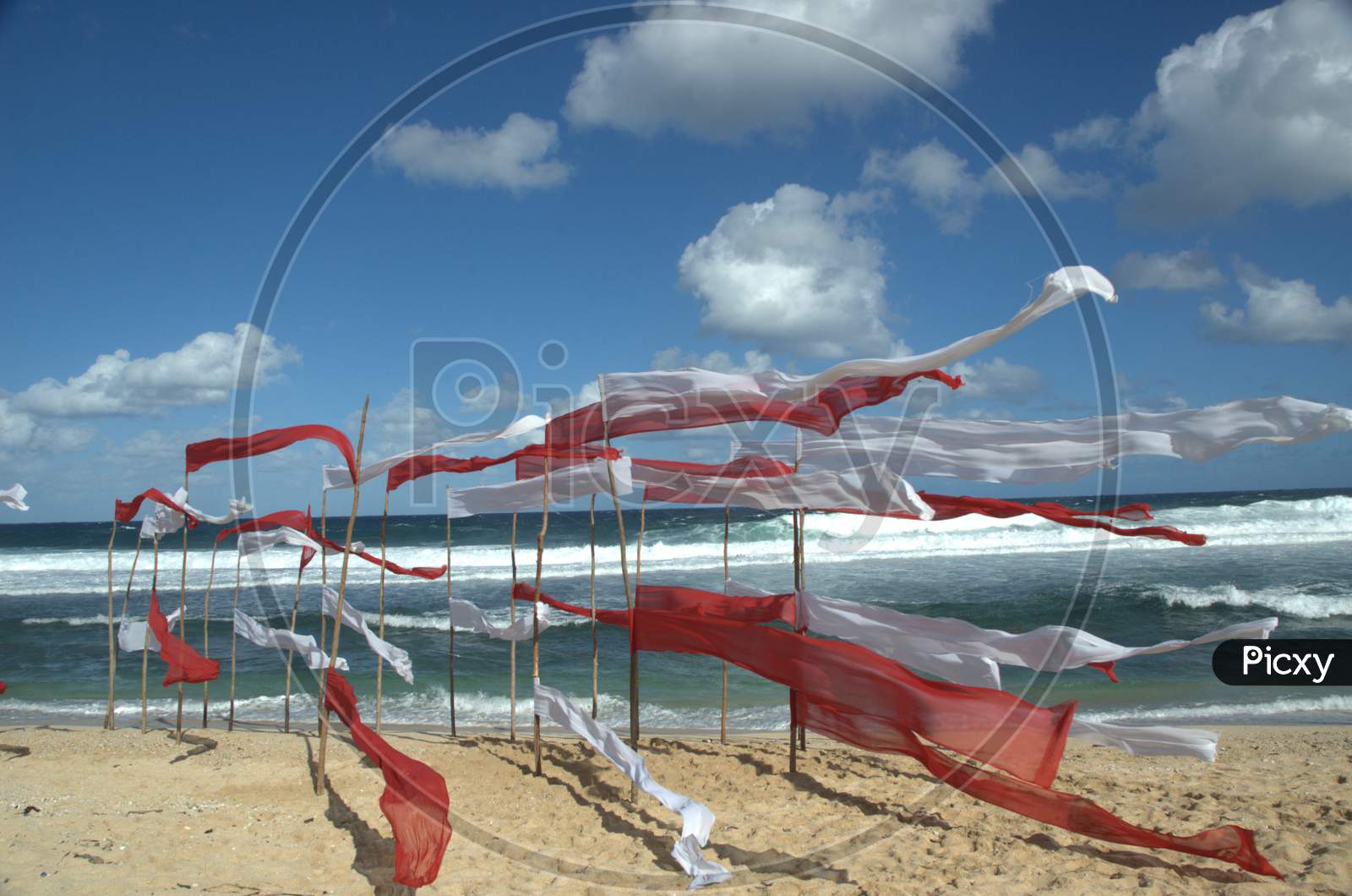 White And Red Clothes  Tagged To Wooden Poles in a Beach