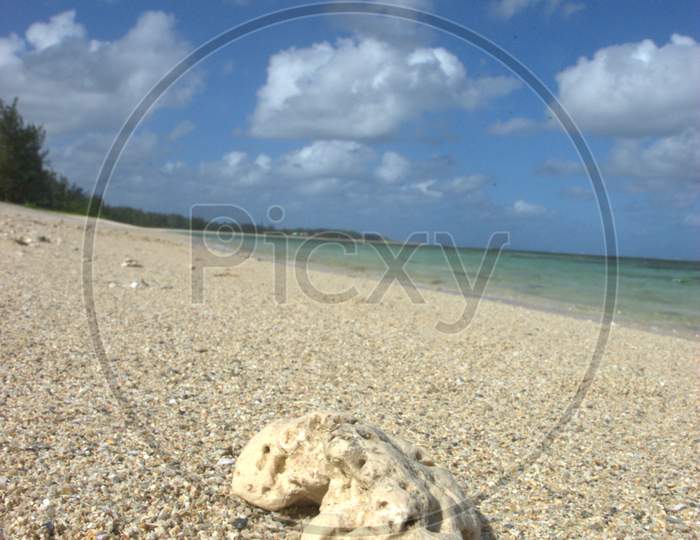 Corrosive Stones on Beach Sand With Blue Sky Background
