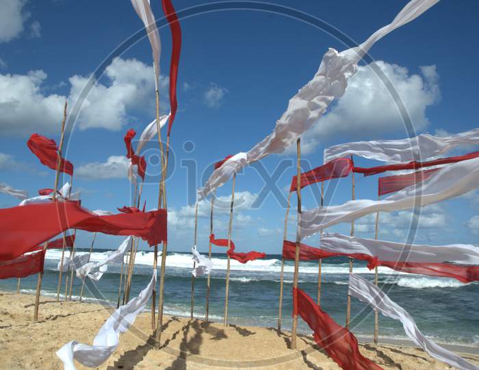 White And Red Clothes  Tagged To Wooden Poles in a Beach