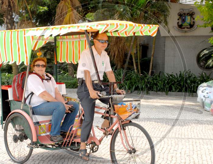 An Elderly Couple Enjoying Tricycle Ride In Bangkok Streets
