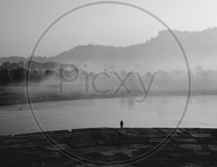 Minimalist Of a Man Standing at Ganga River Bank Doing Daily Activity  In Haridwar