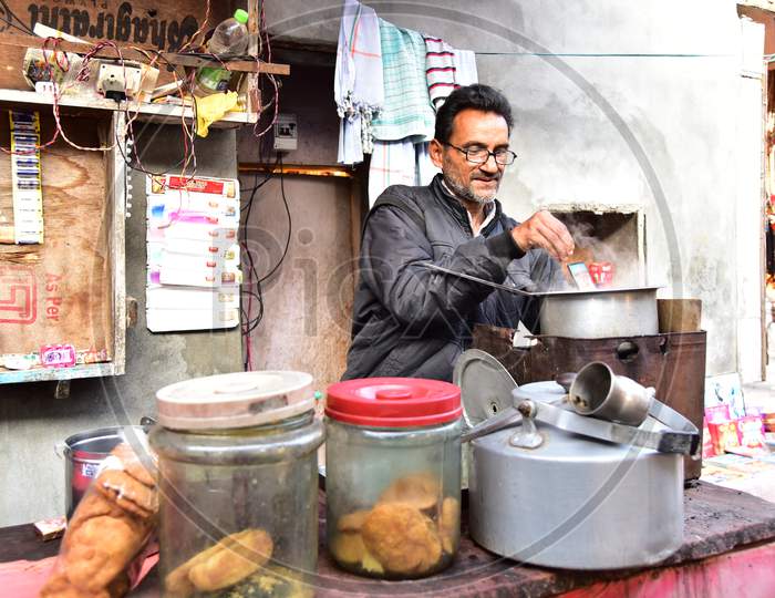 A Tea Vendor Making Tea At a Road Side Vendor Stall