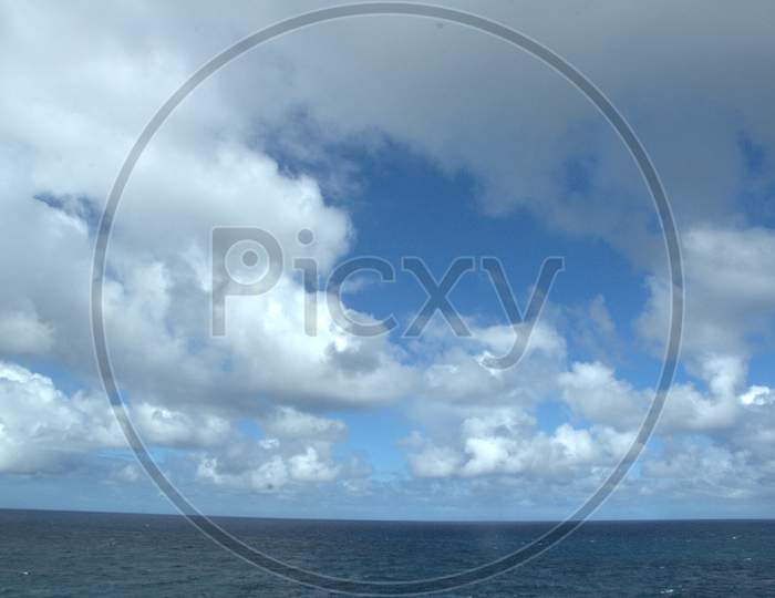 Sea And Sky With White Clouds