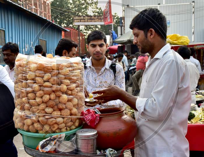 Indian Street Food Panipuri Or Golgappae Vendor Serving At a Road Side Street Food Stall