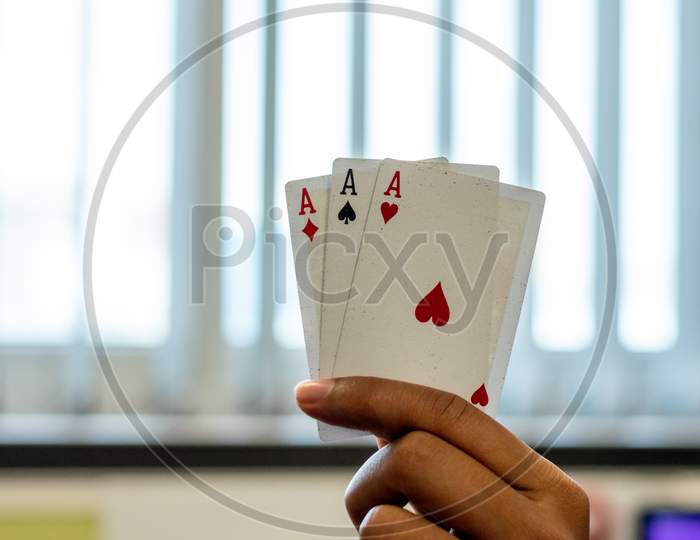 Ace of hearts spades and diamonds playing cards in a hand