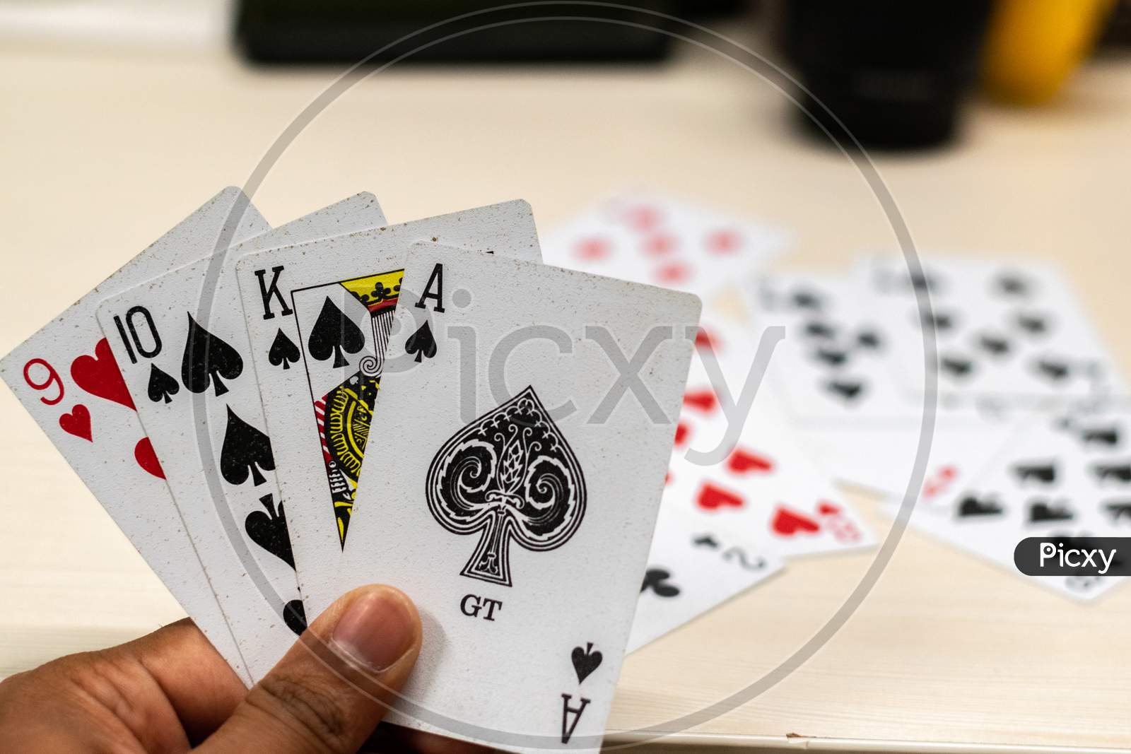 ace king and ten of spades and nine of hearts playing cards with background of other cards