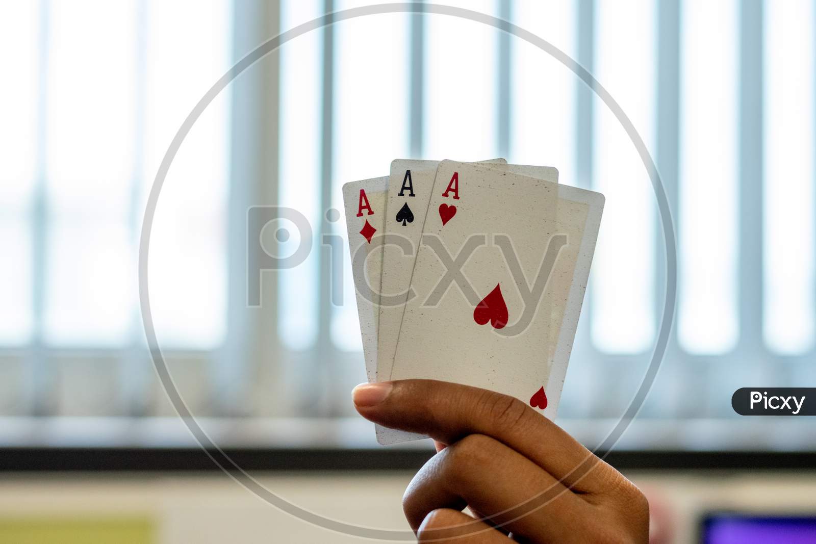 Ace of hearts spades and diamonds playing cards in a hand